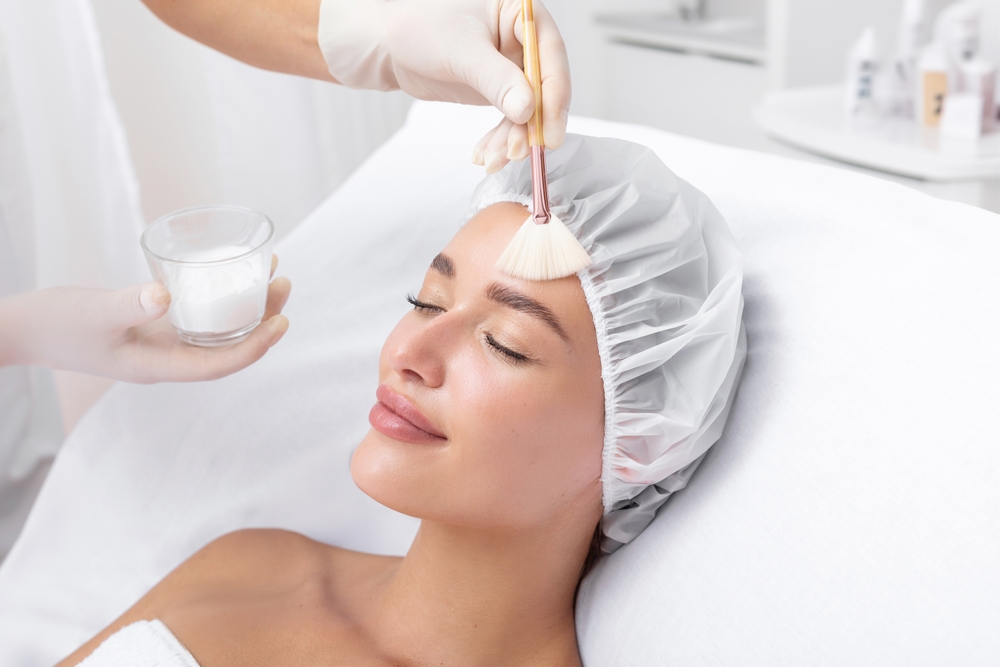 Woman undergoing facial chemical peel treatment for skin rejuvenation at beauty salon or medical spa.